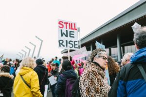 Large peaceful protest with diverse group holding signs about hope, justice and democracy